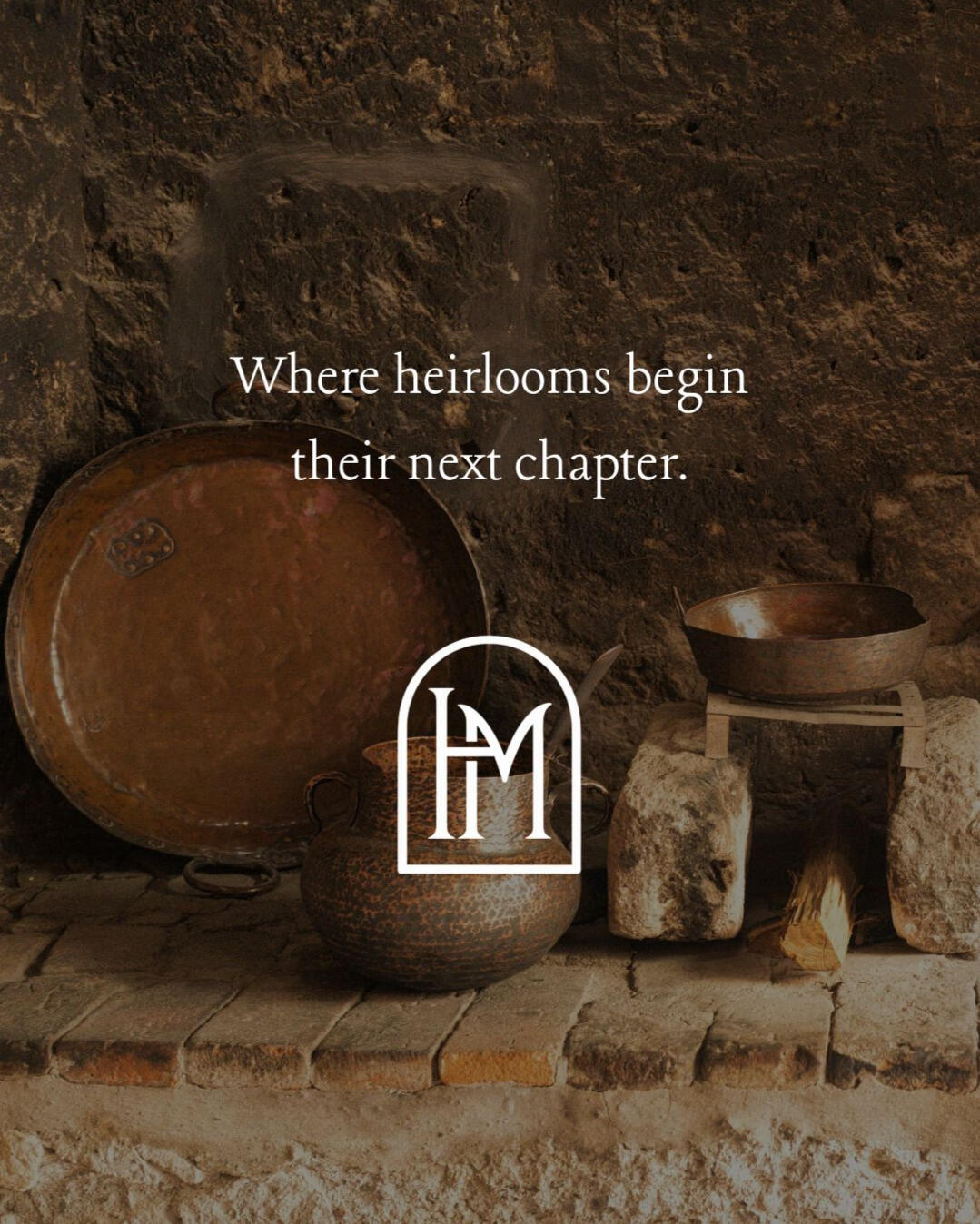 Antique copper and cast iron vessels arranged on a rustic stone hearth with the Hearth Market logo